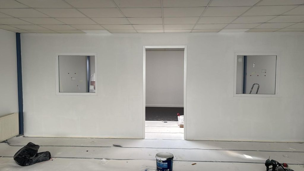 Tussenwand plaatsen kantoor met ramen en deur met kozijnen