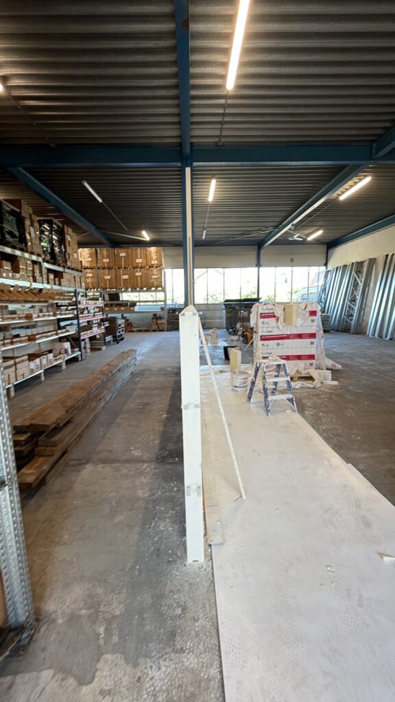 Kopse zijde van een 4,5 meter hoge gipsblokken tussenwand in een loods in Utrecht, geplaatst als scheiding tussen opslag en werkplaats.